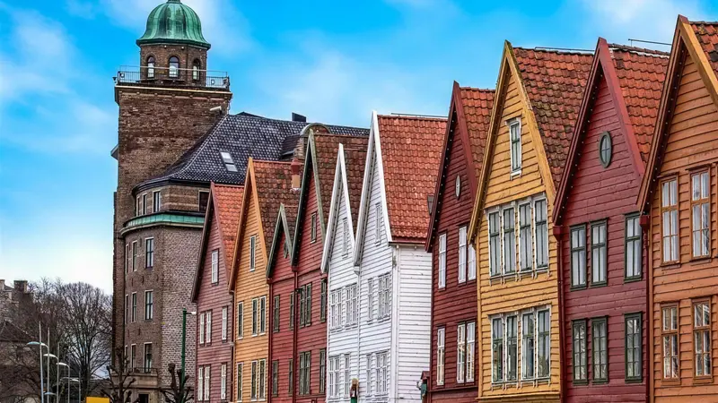 The pointed gabled roofs of the Bryggen wharf houses against a blue sky in Bergen