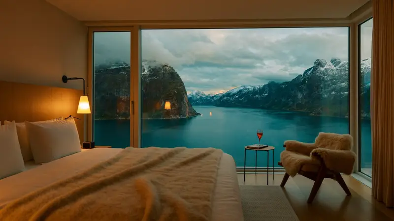 Scandinavian hotel room with floor-to-ceiling window facing a fjord