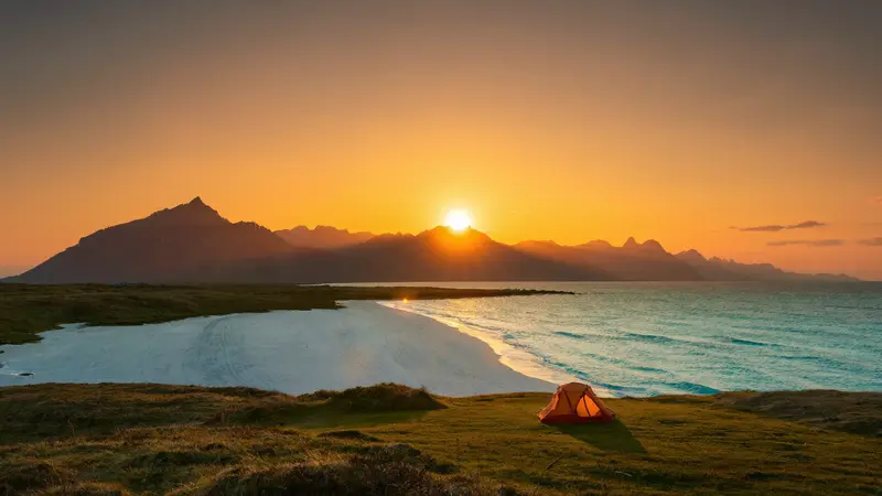 Midnight sun glowing over a white-sand Lofoten beach at 1am