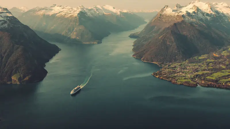 Aerial view along the vast Sognefjord between towering snow-topped mountains